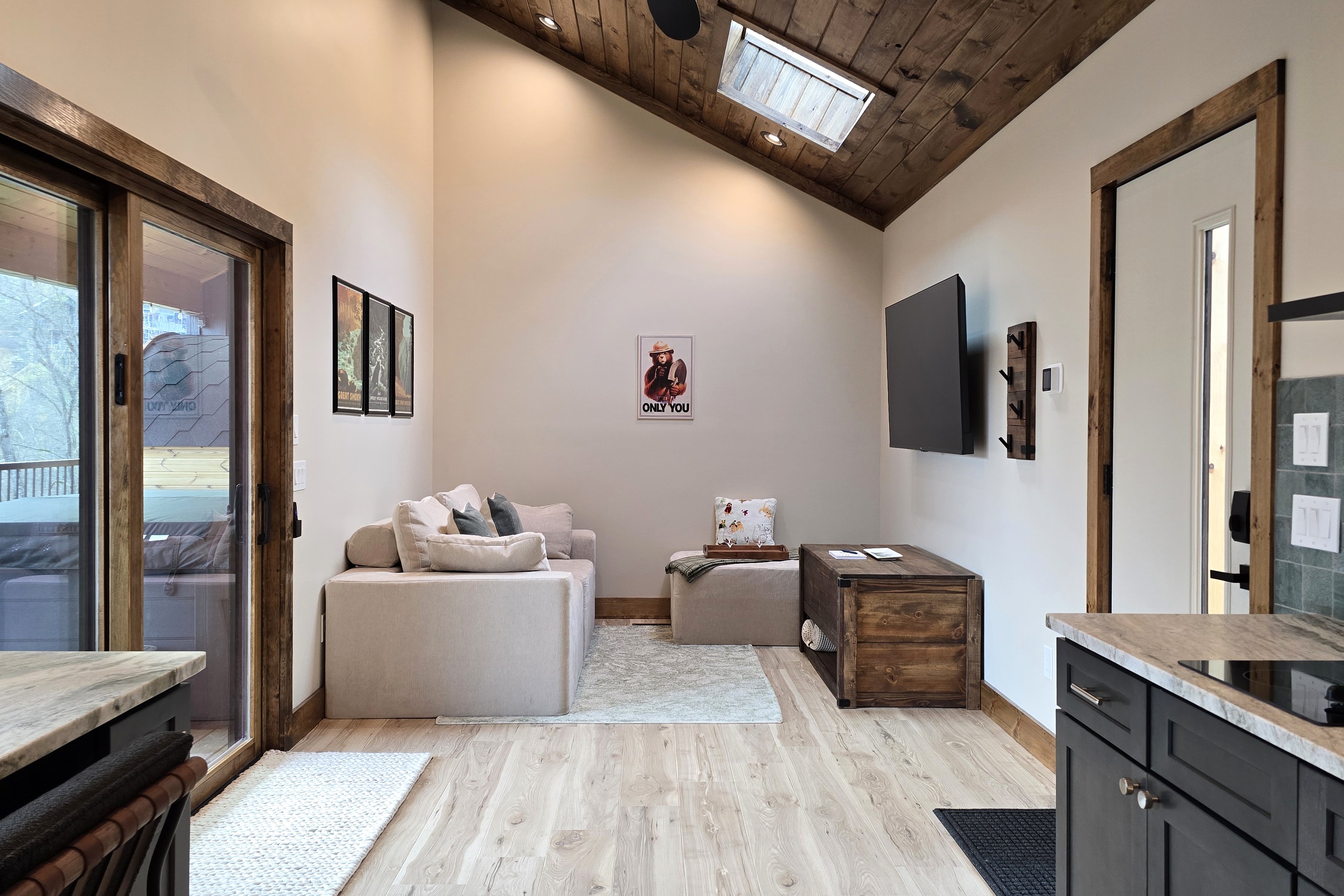 Living room with 65" Roku TV and sky window