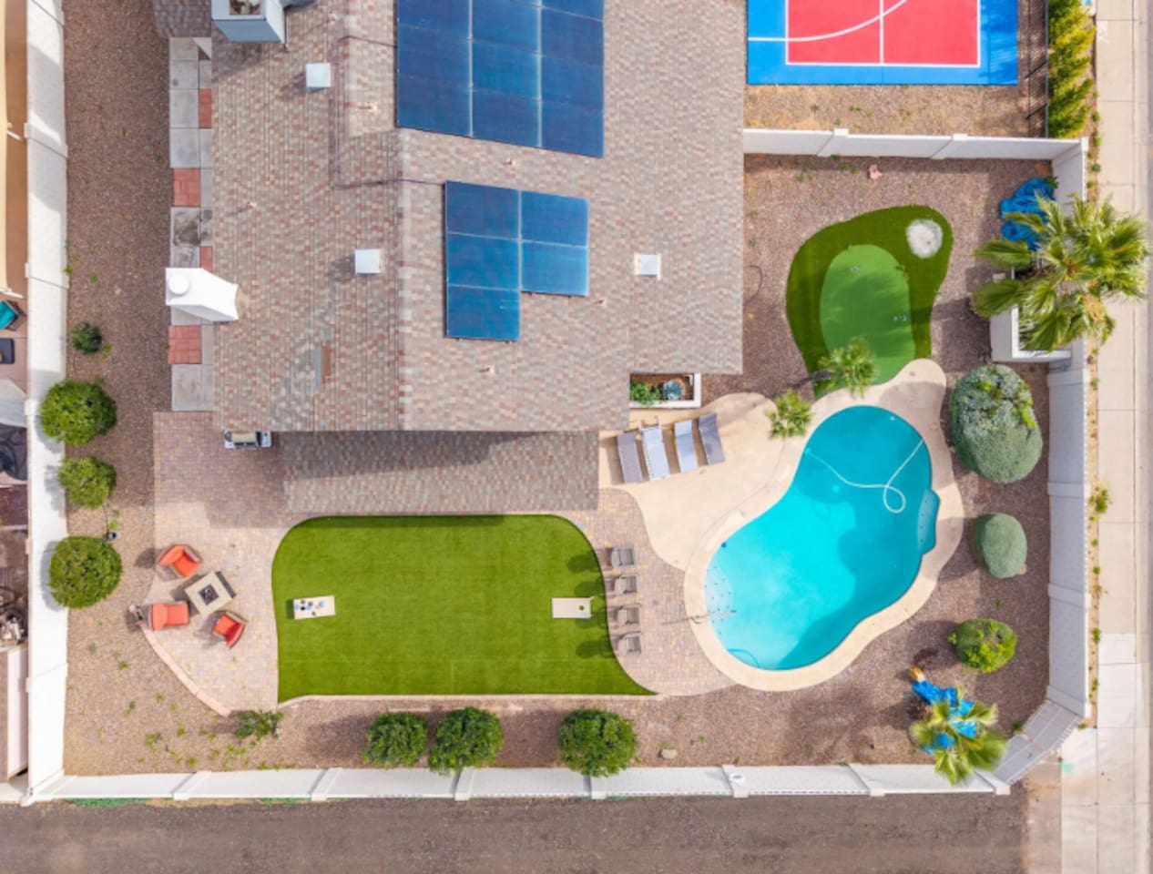 Urban backyard retreat with resort pool, sports court, putting green, and expansive lawn.
