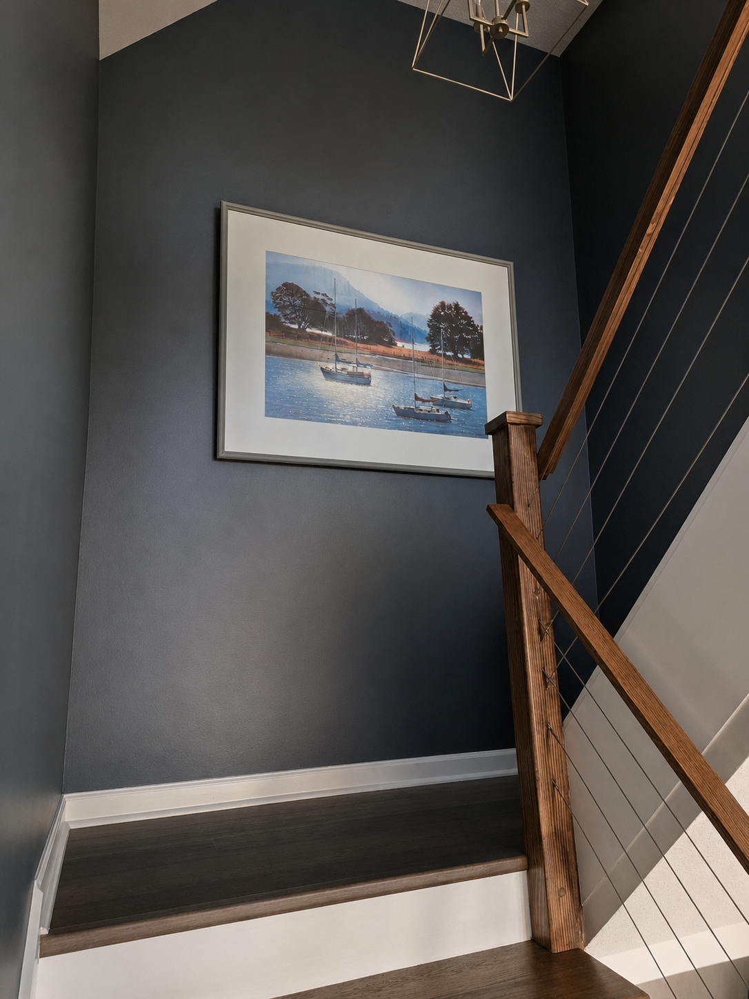 Main-level stairway with lake-inspired artwork and access between the living room and loft.