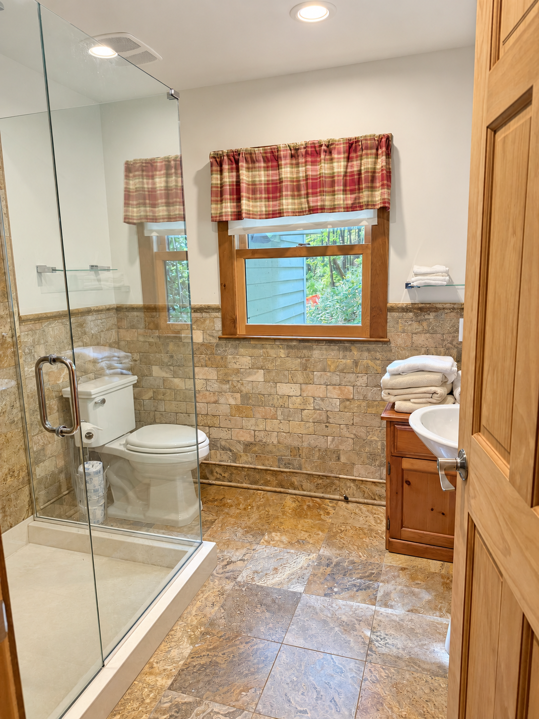 Bathroom with wide tiled shower and frame-less glass surround