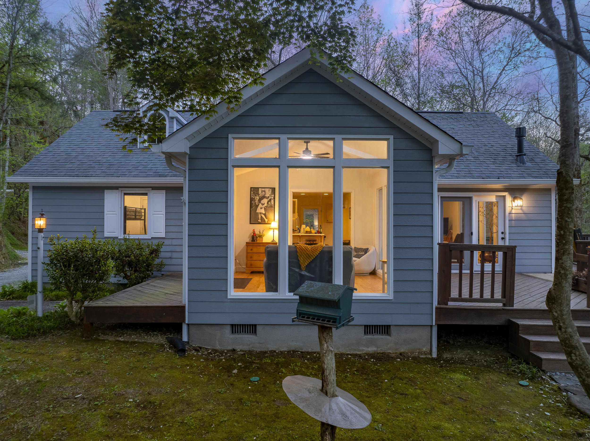 Exterior: Charming retreat surrounded by nature, with bright windows and a welcoming deck!