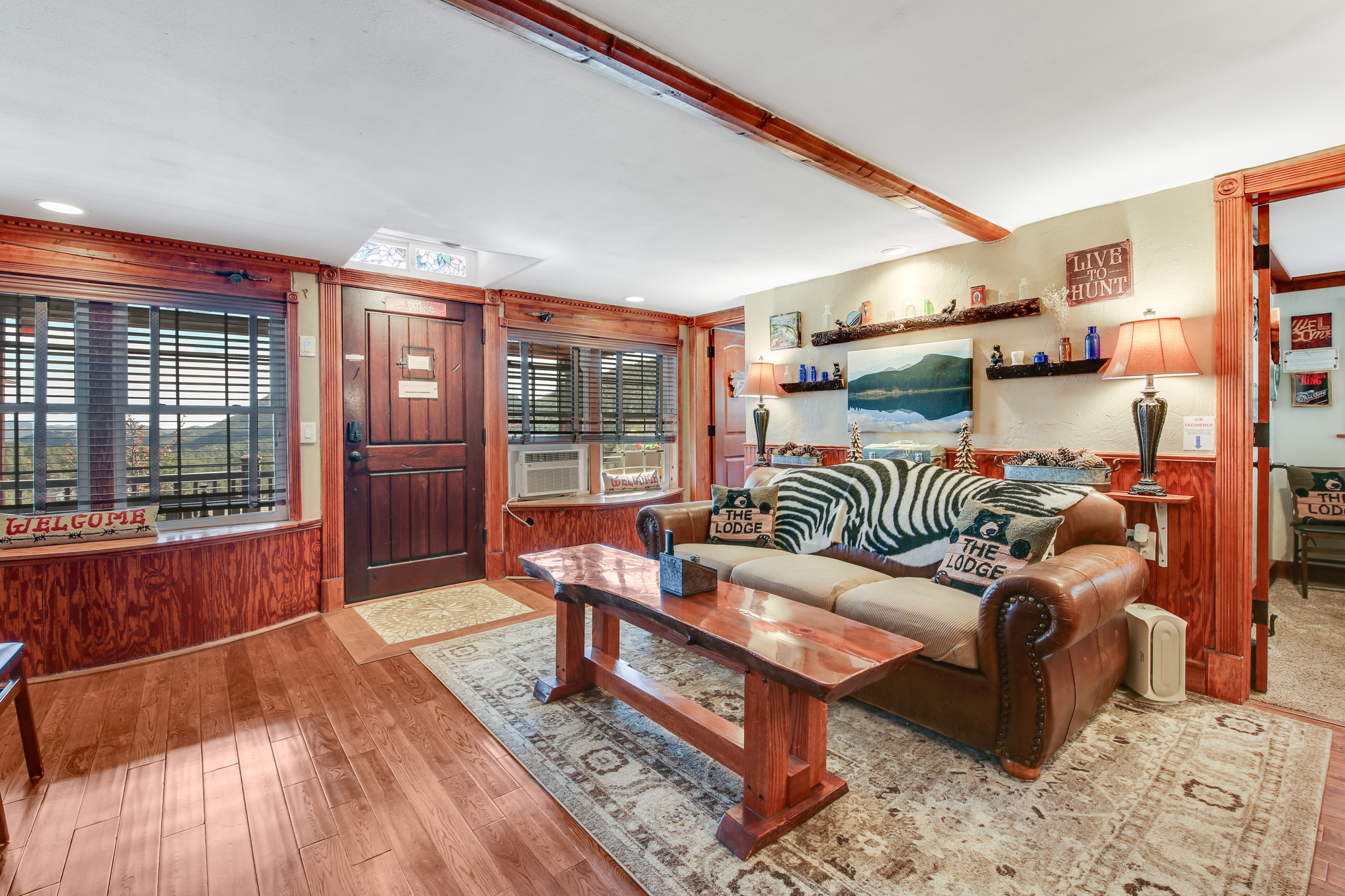 Cozy living room with leather seating and warm lodge‑style finishes.