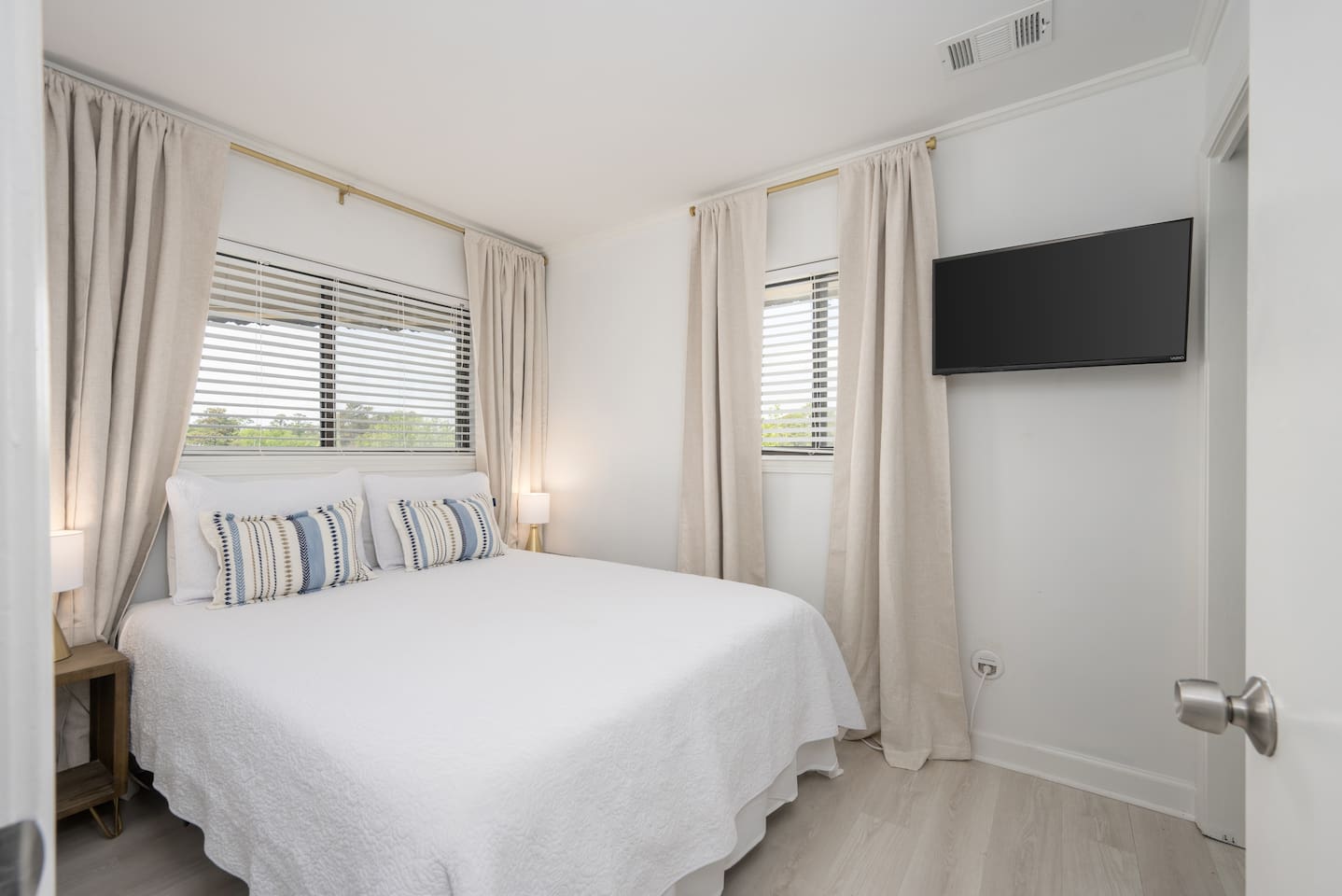 Private bedroom featuring a new ADJUSTABLE queen bed, closet, nightstands and a smart TV. 