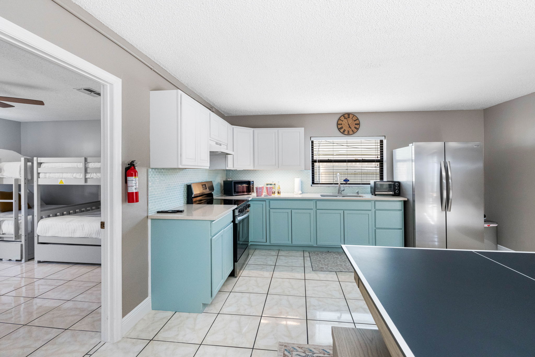 Soothing two-tone cabinetry in crisp white and soft seafoam green gives this kitchen a light, airy feel.