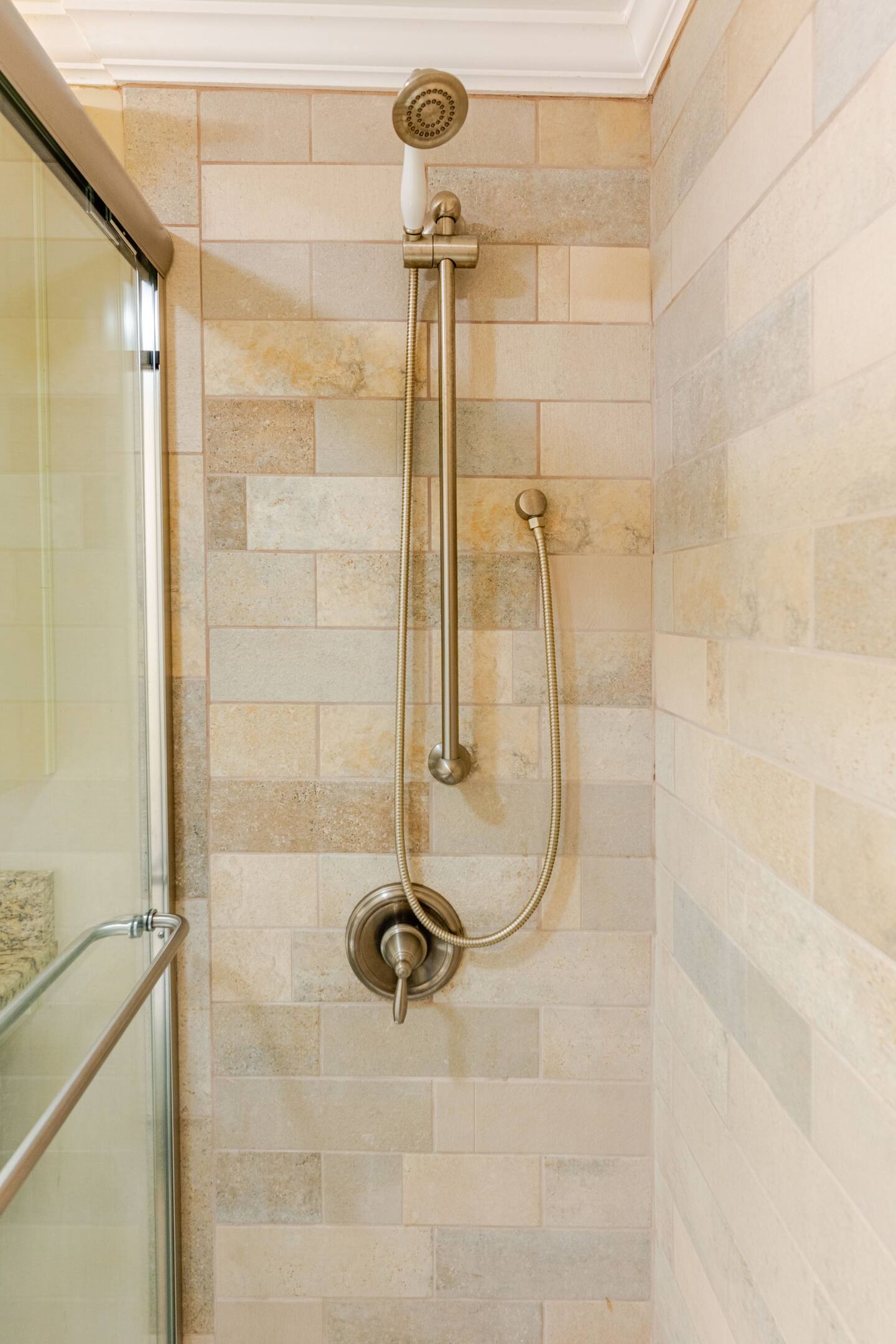 A luxurious master bathroom featuring a beautiful shower with elegant glass doors and a stylish showerhead.