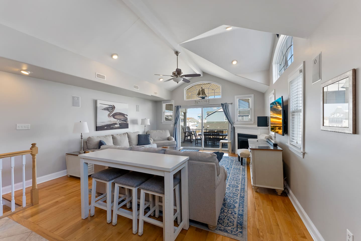 Spacious Living Room with fireplace, HDTV, and access to private balcony with views of the ocean.