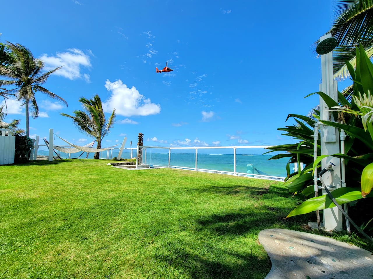 View of Baywatch Hawaii helicopter while sitting in the home's 7-person beachfront jacuzzi, which is the third jacuzzi on the home's beachfront garden
