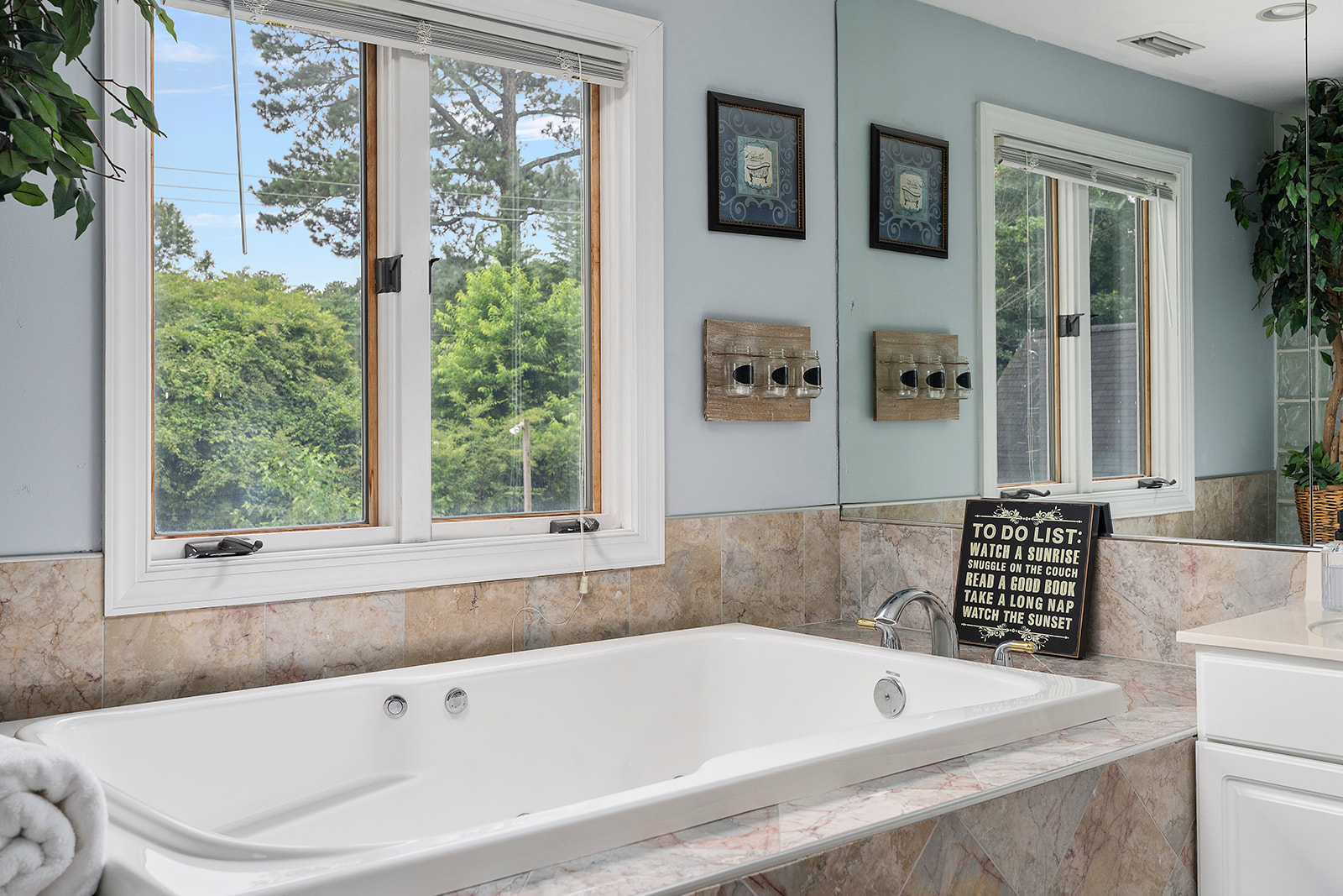 Master Bathroom 1: Relax in the soaking jacuzzi/tub with views of lush greenery and serene decor!