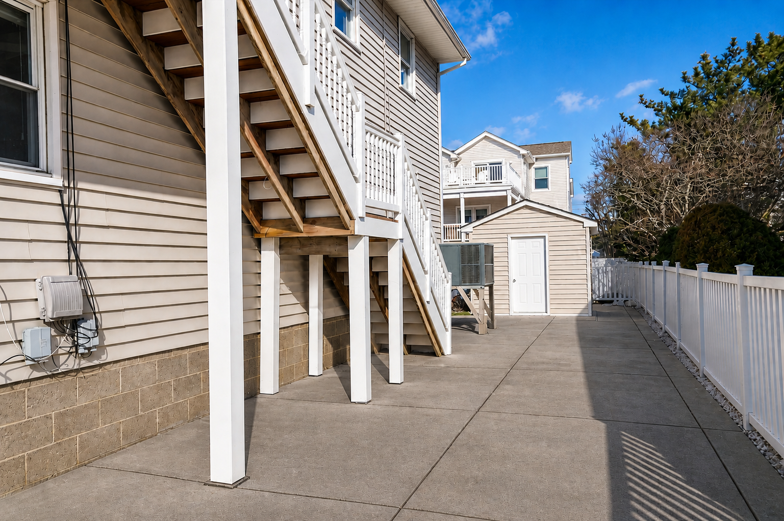 On the right side of the house, stairs lead up to the upper level.