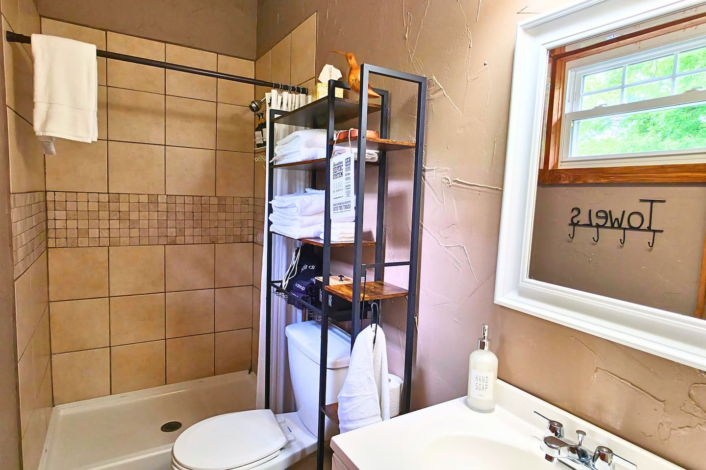 Enjoy a clean, fully stocked bathroom with fresh towels, makeup cloths, and a spacious walk-in shower. 