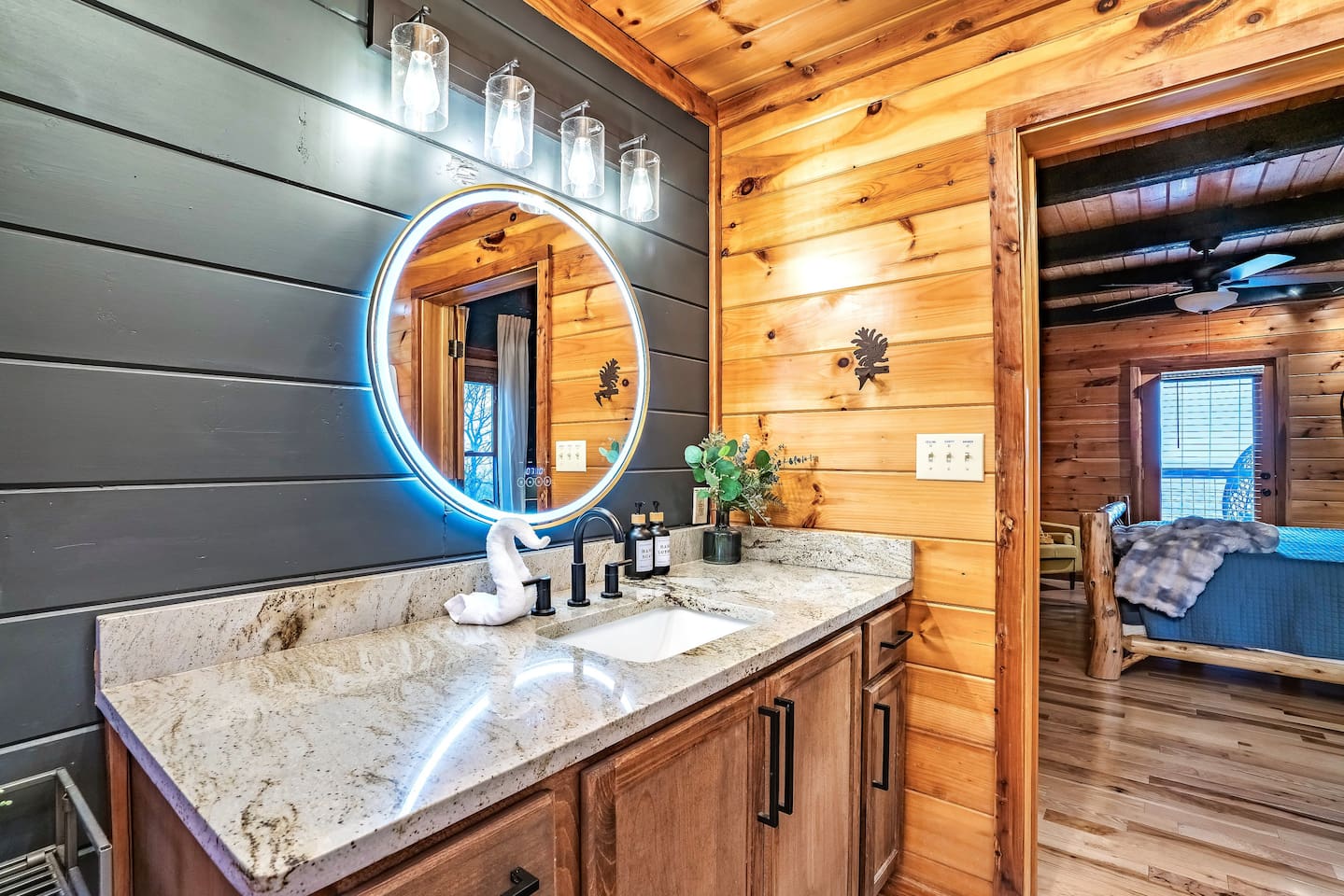 Inviting master bathroom featuring a dark accent wall, backlit vanity mirror, and modern fixtures for a spa-inspired experience.