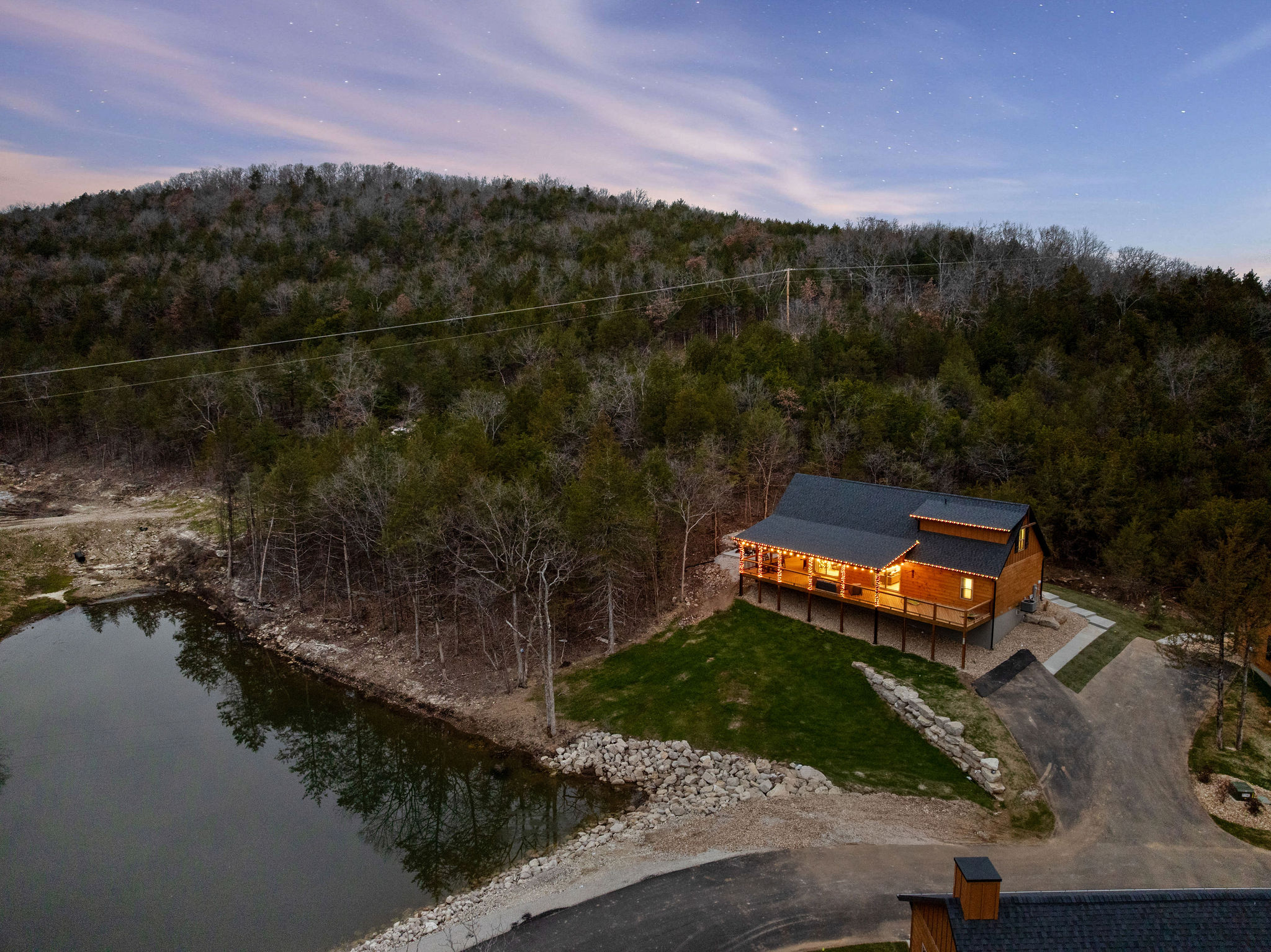 Scenic aerial view of the cabin set near the water and trees.