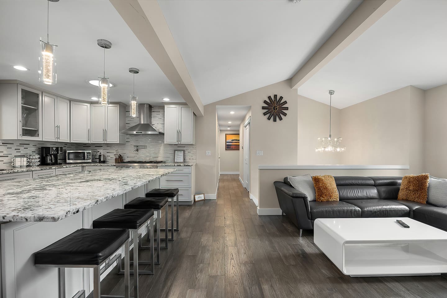 “A beautifully designed open kitchen and living area with modern décor, a large island, and comfortable seating, creating a welcoming and connected space.”