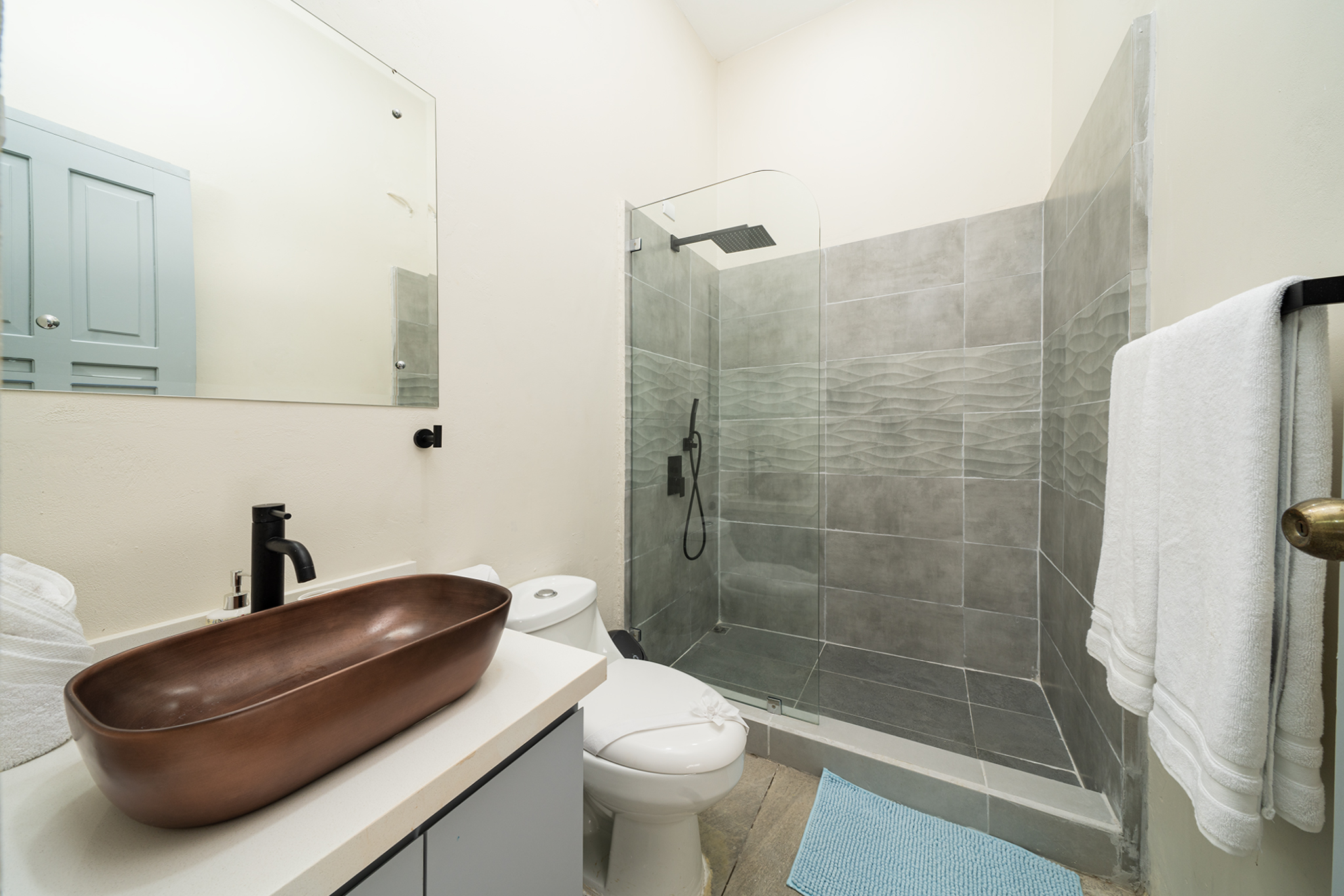 The ensuite bathroom has a walk in shower and copper sink