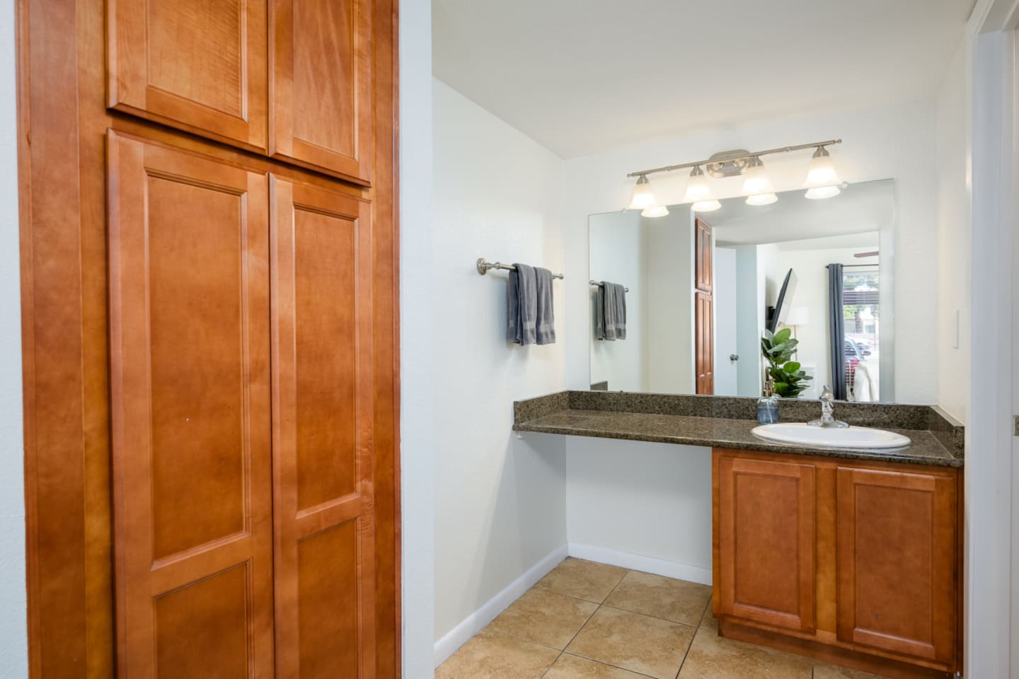 Bathroom vanity with counter space, cabinet storage, bright lighting, and a clean setup for daily routines.