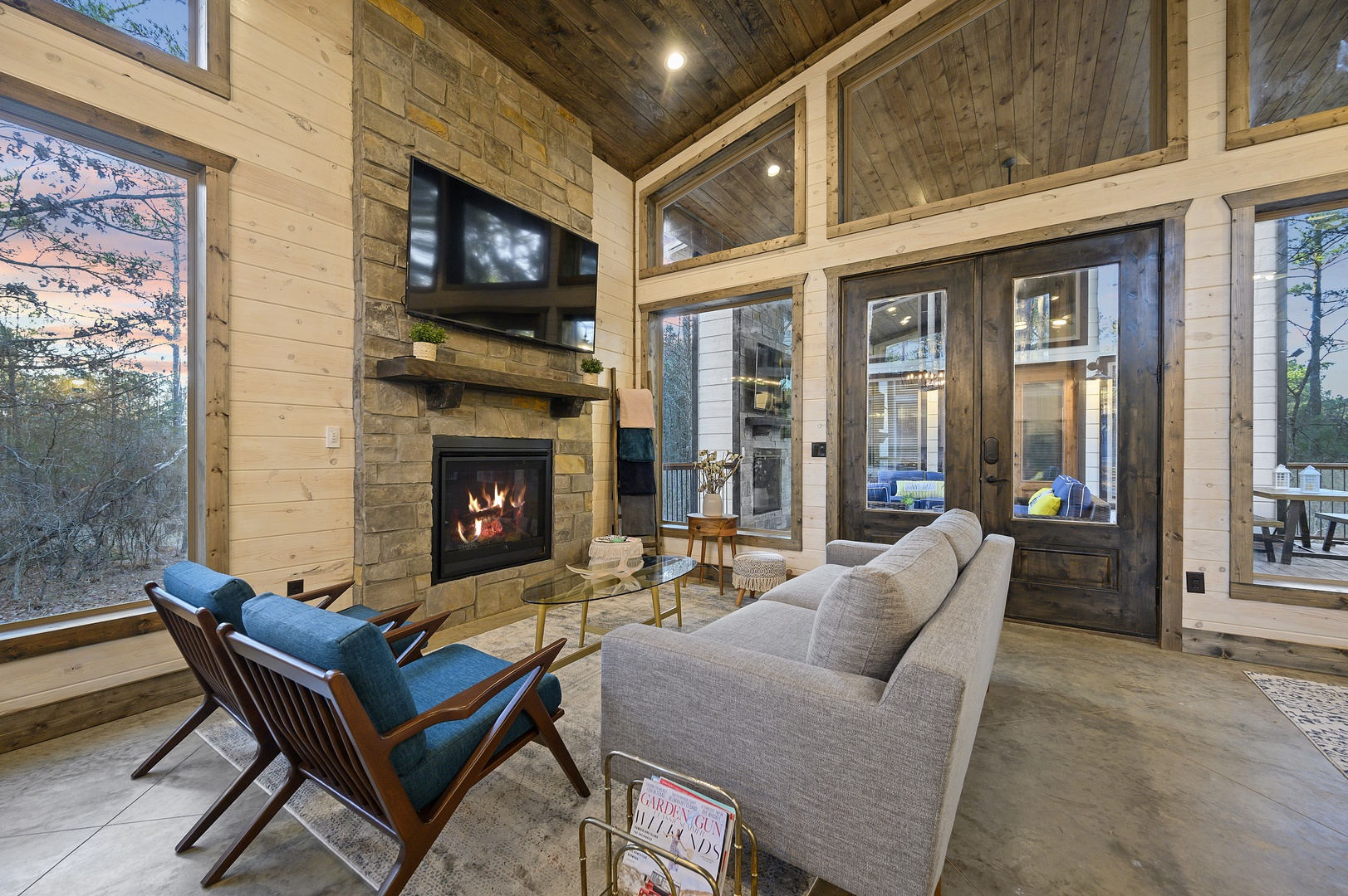 Settle into plush seating as twilight settles over the forest. The fireplace glows, the TV is ready for the game, and the whole space feels made for cozy nights in.