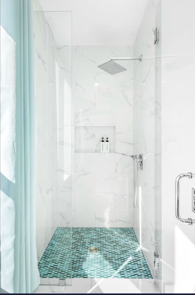 Bright Master Bath with a tall, smart LED shower that changes color with the water temp!  Featuring bespoke coastal cabinets, a unique custom sink, and floods of natural light. A serene, spa-like retreat designed for your ultimate comfort. ✨
