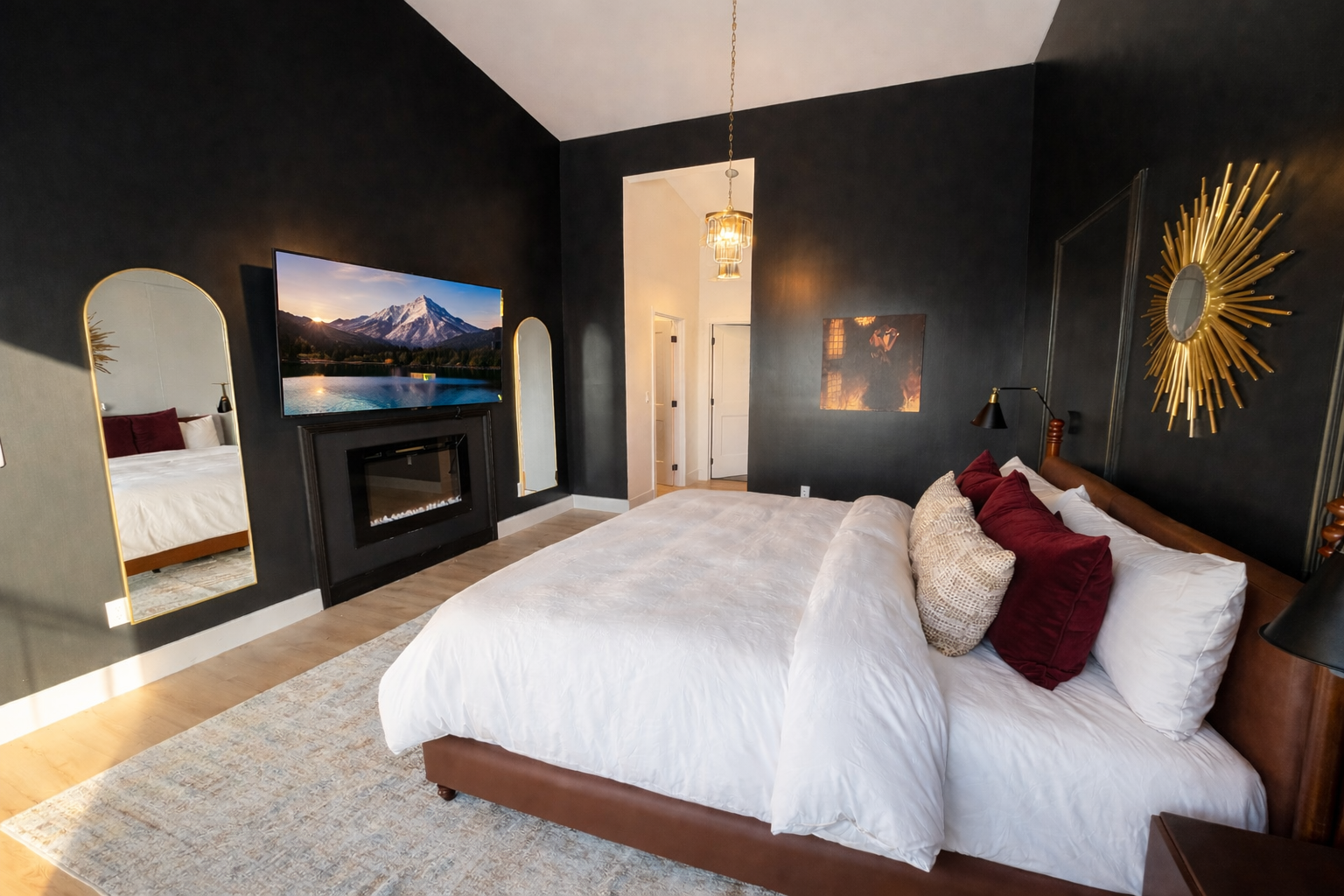 Master King Suite — a dramatic, moody retreat designed for true relaxation. Sink into a plush king bed, unwind by the in-room fireplace, and stream your favorite on the 65"TV.