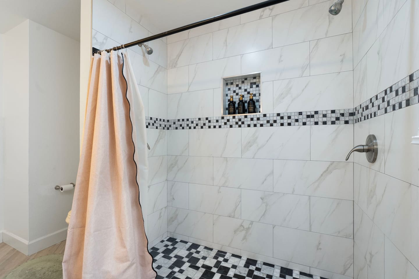 Walk-in shower with marble tile, mosaic trim, and built-in niche—a sophisticated spa-like retreat for daily indulgence.