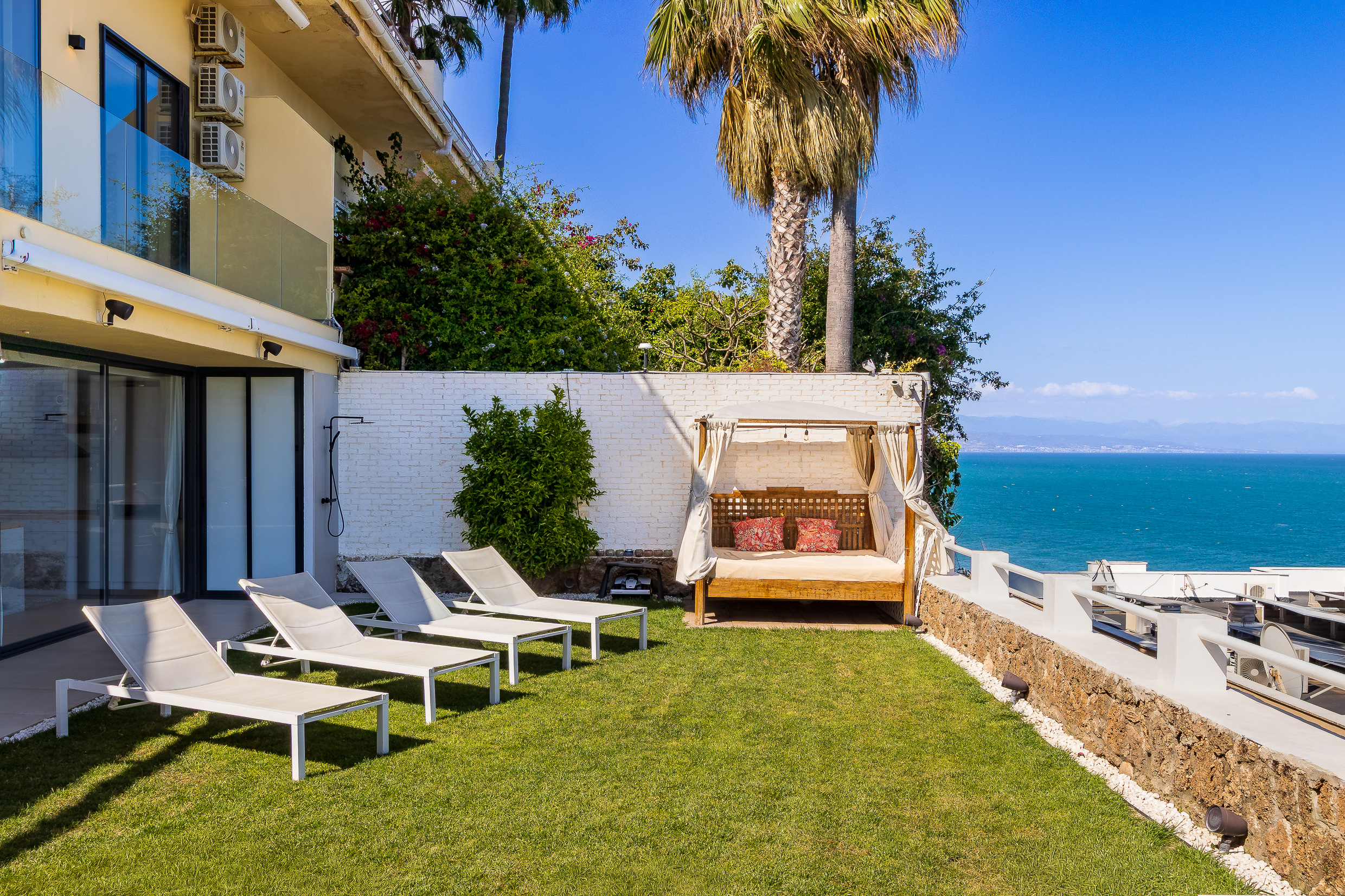 Private garden with loungers and a daybed facing the sea