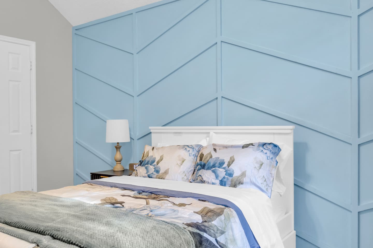 Well-appointed queen bedroom with blackout blinds, ceiling fan, high-speed Wi-Fi, modern décor, and cozy bedding designed for family and group stays.