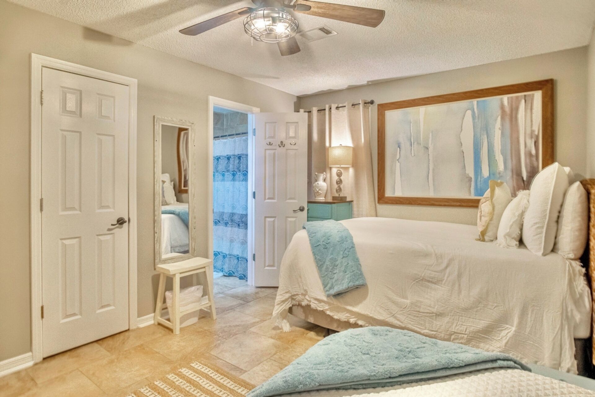Guest bedroom with ceiling fan, smart TV, and ensuite bathroom