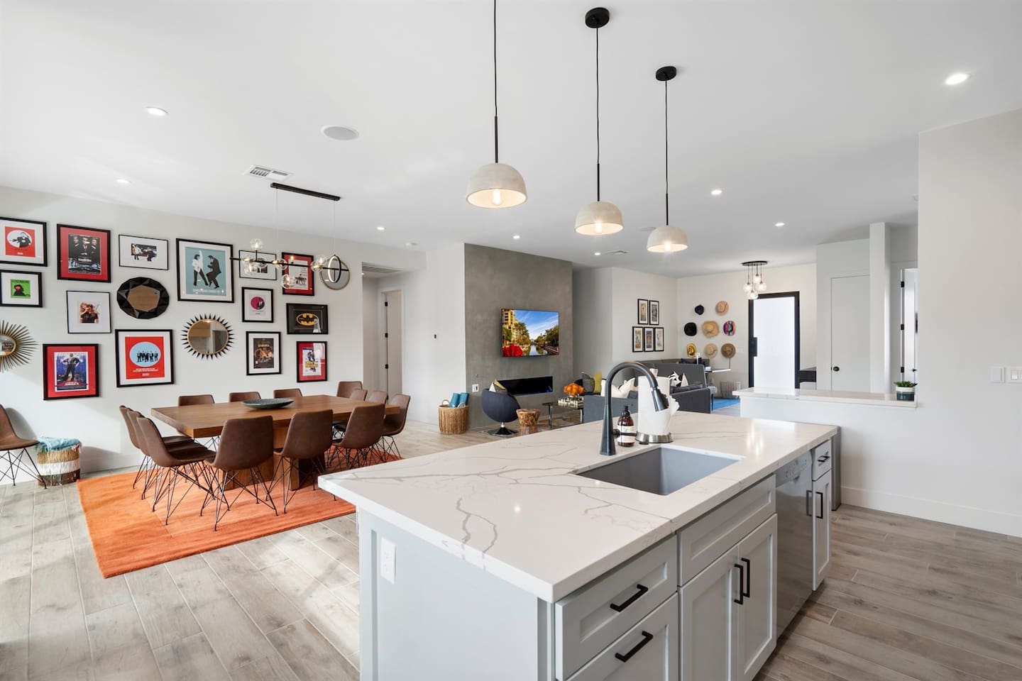 Stunning kitchen with an island sink, gas range, wine cooler, and coffee area. The white theme, paired with marble and wood accents, creates a bright, inviting space for cooking and gathering.