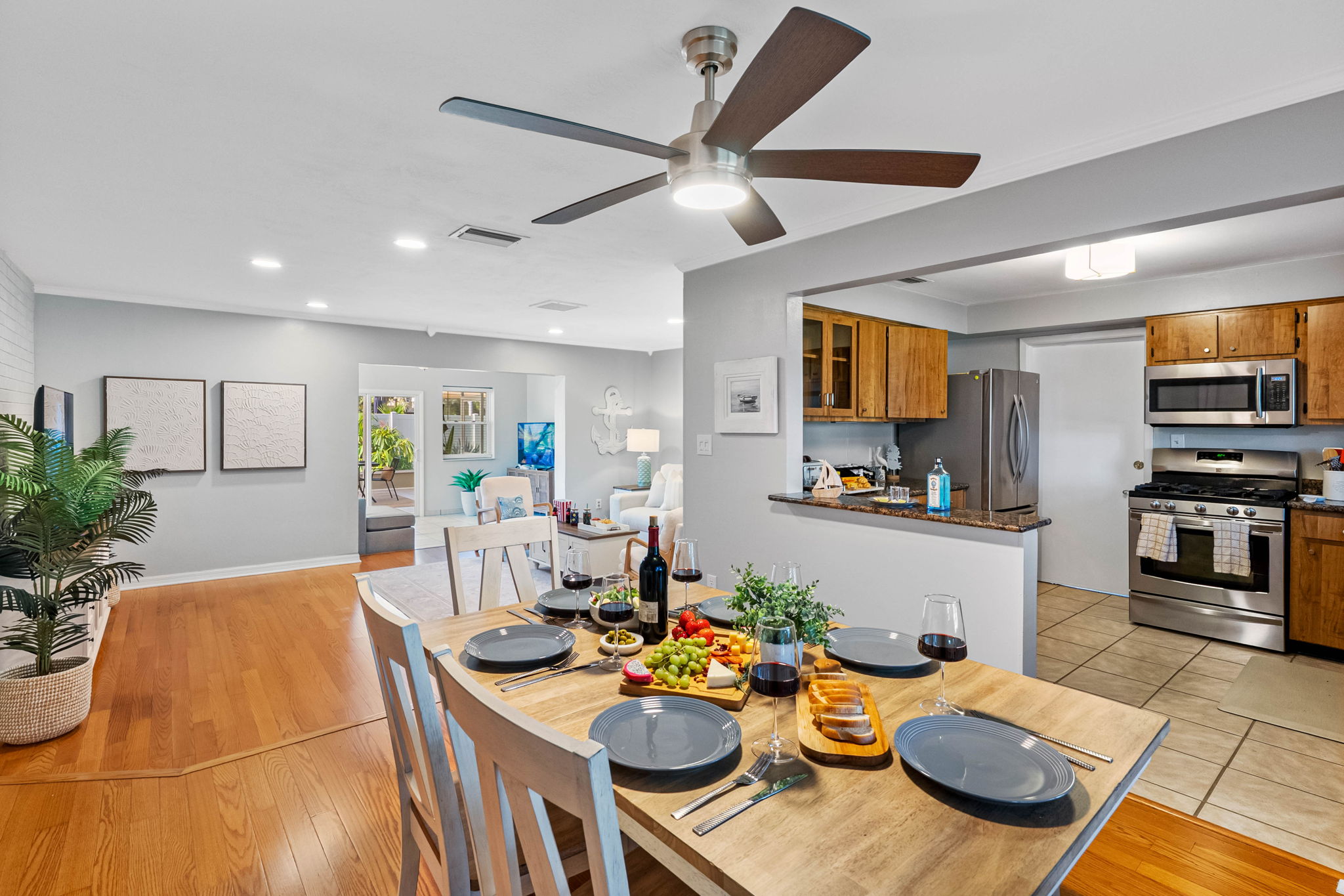 Tucked between a cozy living area and a fully stocked kitchen, this welcoming dining setup blends convenience and charm—ideal for anything from family dinners to celebratory toasts.