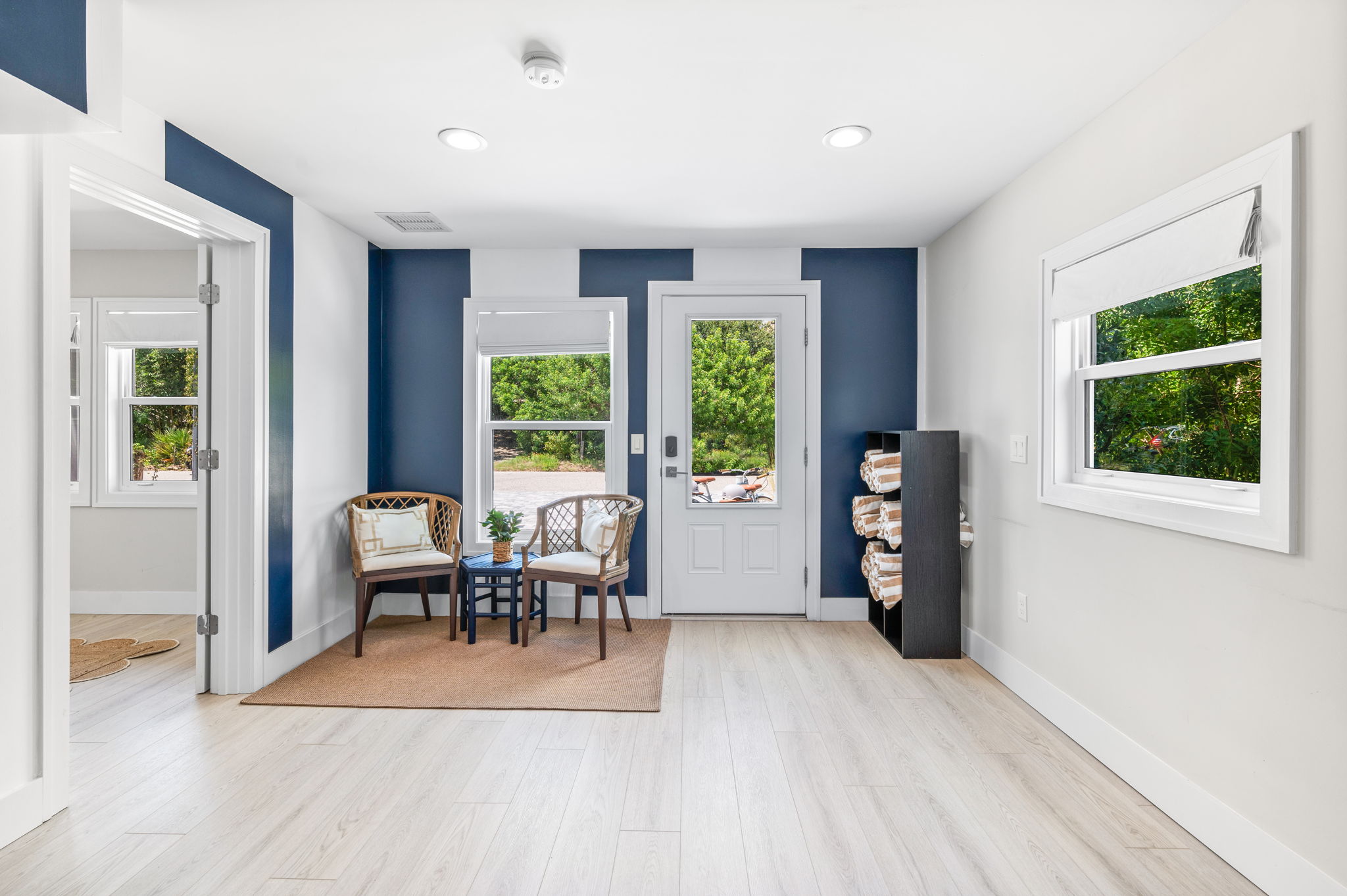 Step into the spacious front foyer—one of the standout features of the home! With bold navy blue and white stripes that add a playful touch, this oversized entryway includes a towel station, perfect for grabbing a rolled towel on your way to the beach, and