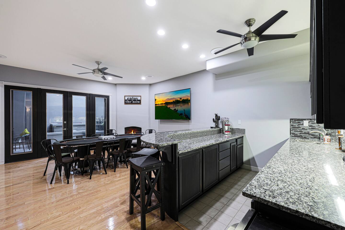 Sleek wet bar setup with granite counters and modern backsplash, ready for snacks and drinks during game night.