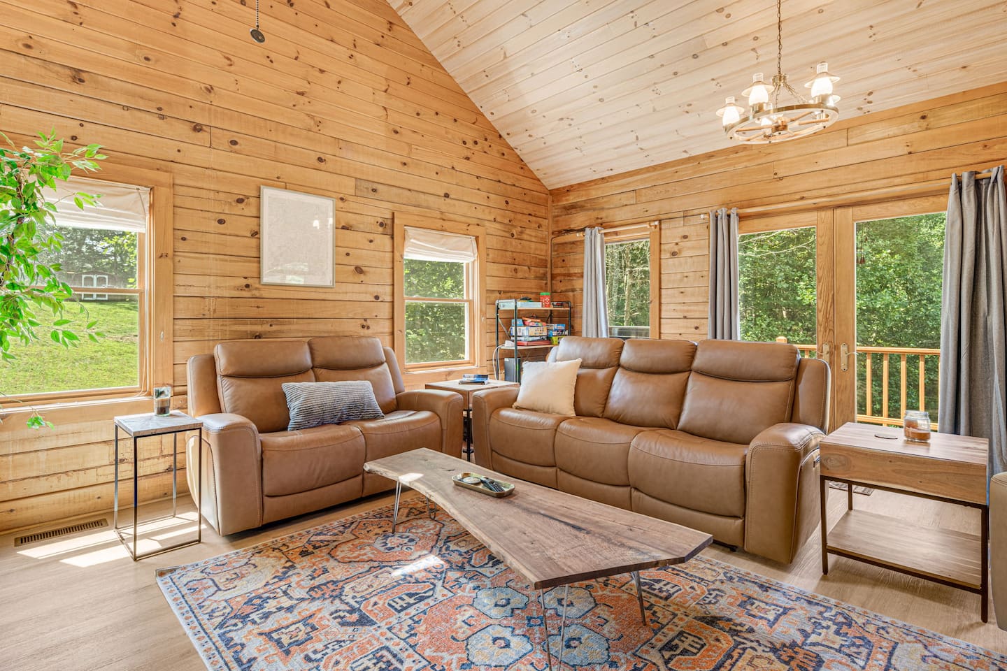 This living room invites you to relax by the stone fireplace, stretch out on soft leather seating, and soak in the beauty of nature through expansive windows. The perfect place to recharge after a day of adventure!