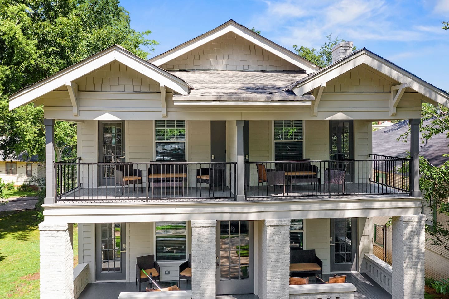 A picturesque view of the Avenue Quads showcasing its charming architecture and welcoming front porches surrounded by lush greenery.