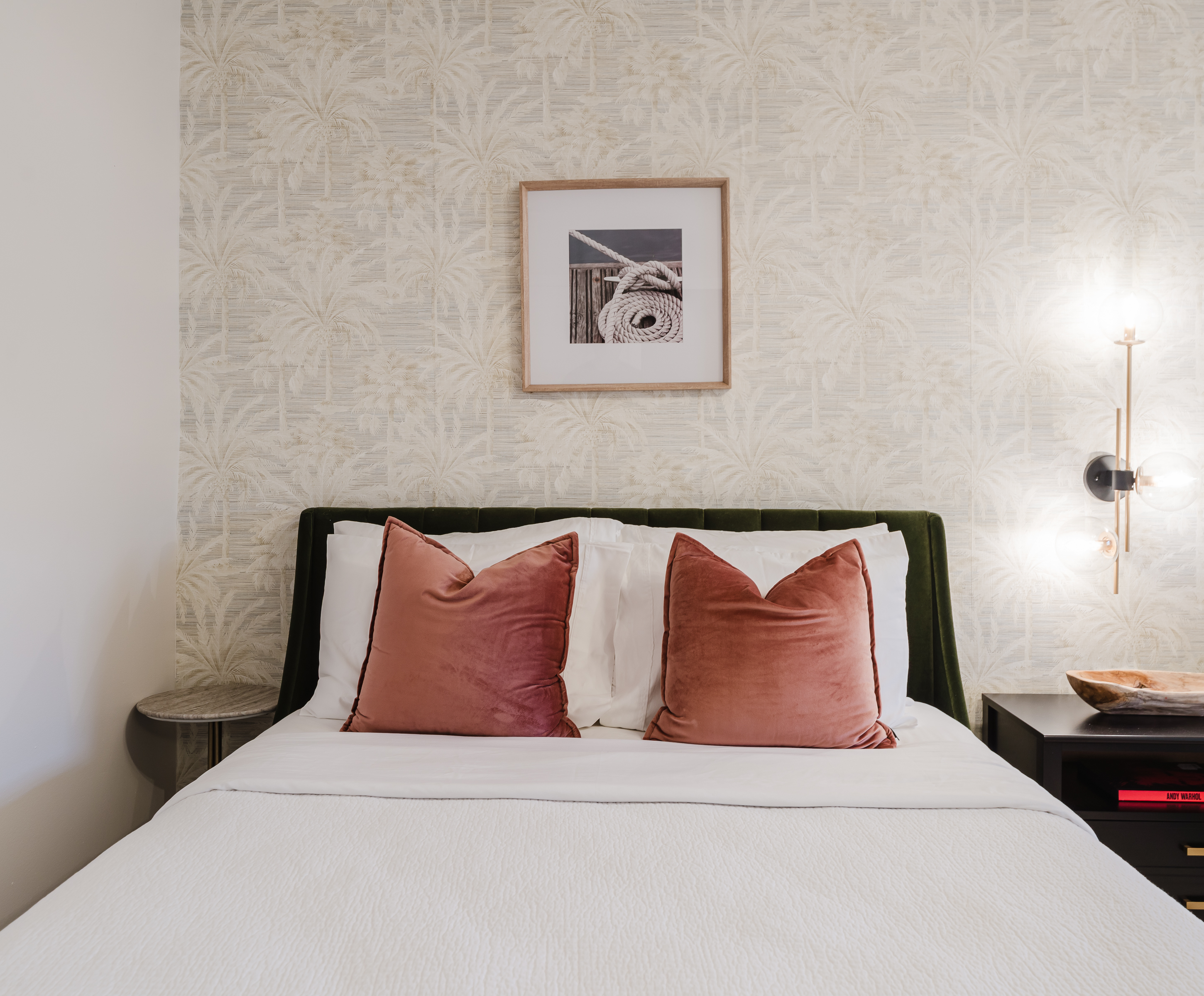 Bright coastal suite with two queen beds, private ensuite bath, smart TV, blackout bamboo shades, and a rattan ceiling fan—ideal for families or shared stays.