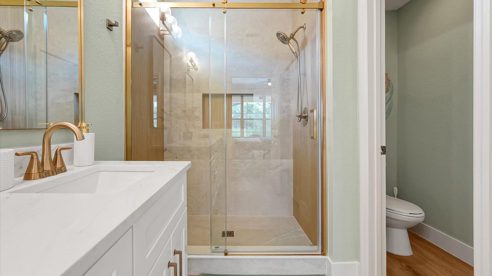 Moana King Suite Ensuite: Custom-tiled walk-in shower with a handheld showerhead and separate toilet room.