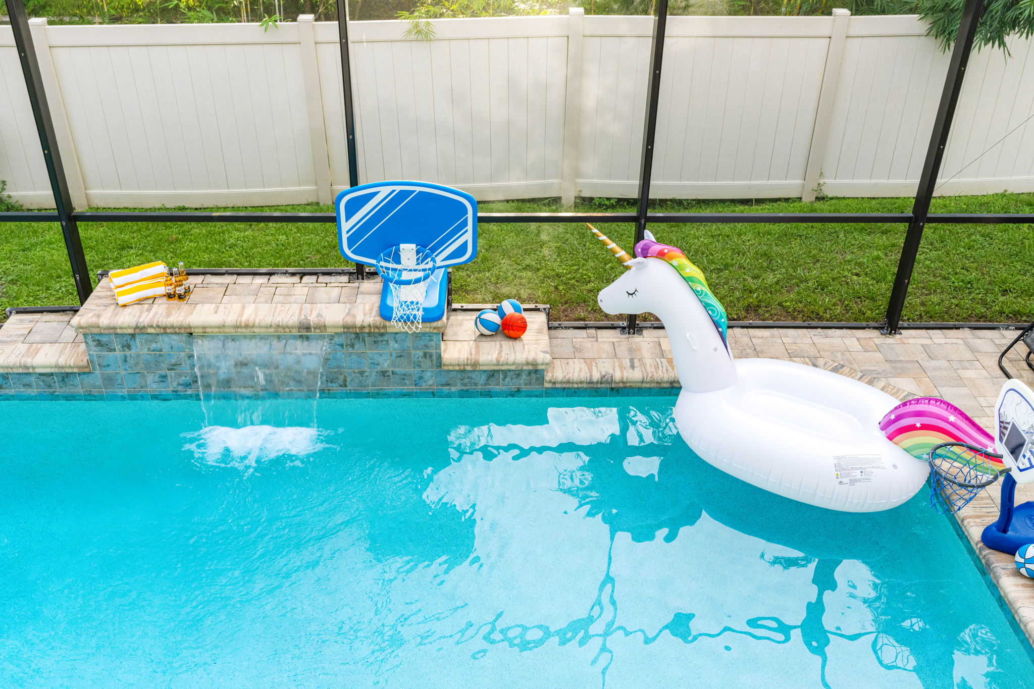 Unwind under the cascading water feature or float lazily beneath the screened ceiling—your peaceful pool escape awaits.