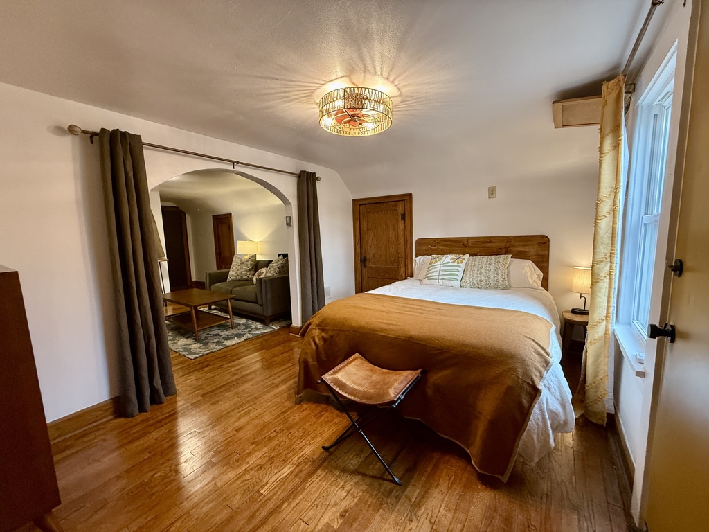 Bedroom with plush Queen size bed, multi-plug charging bedside lamp.