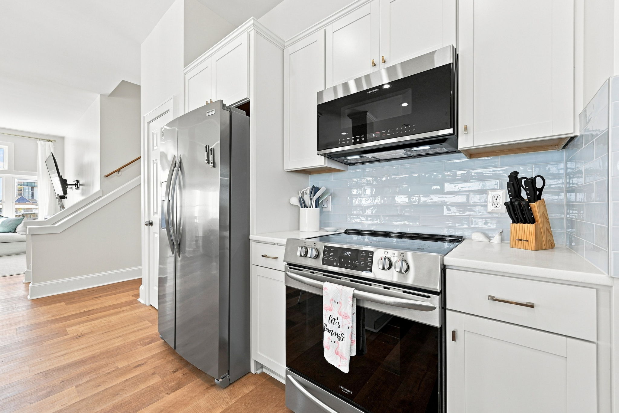 Sleek stainless steel appliances add a modern touch to this bright, open kitchen designed for gathering and entertaining.
