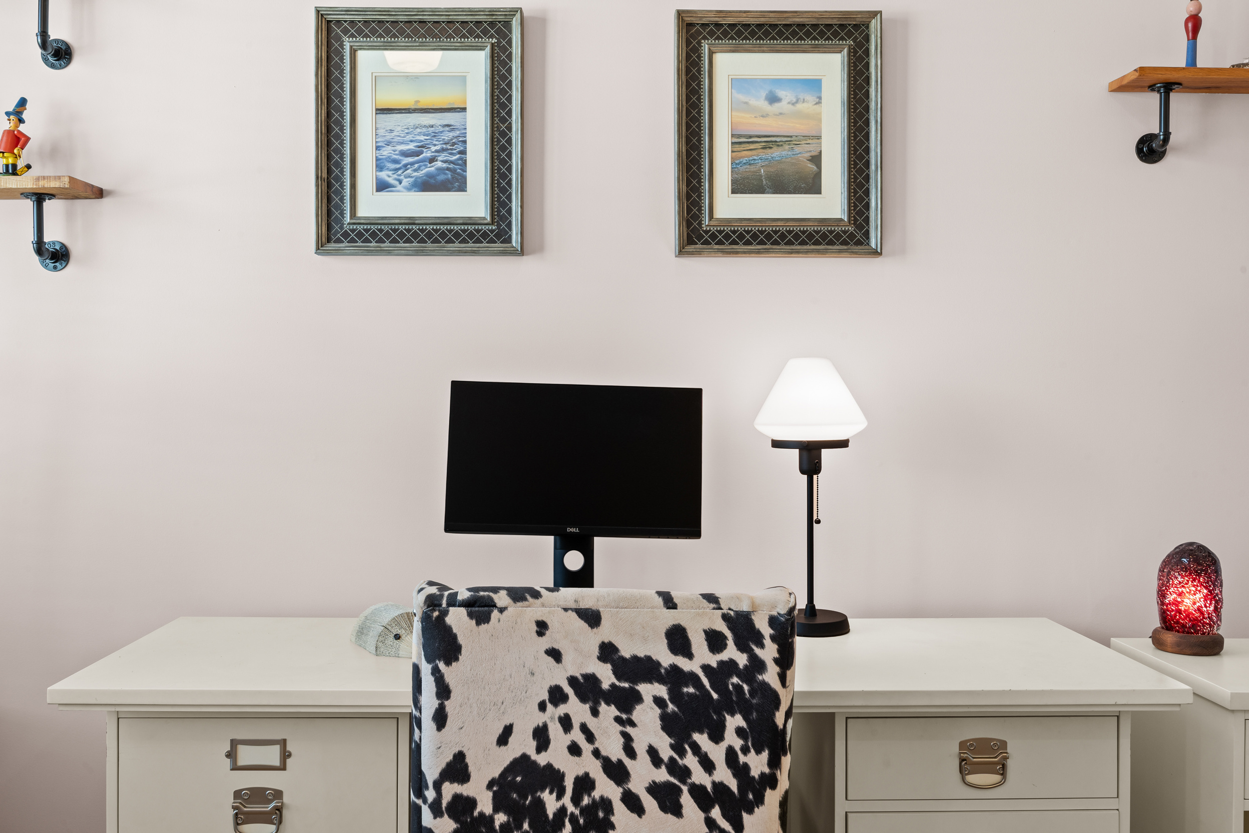 Comfortable desk setup with beach‑themed art — perfect for remote workers.