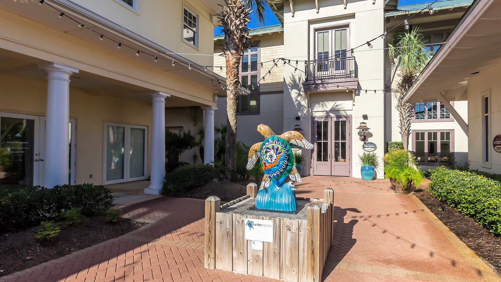 The vibrant heart of The Beach Club Resort entrance: The Village Square. Discover a delightful array of restaurants, amenities, and stores, all conveniently located to enhance your stay.