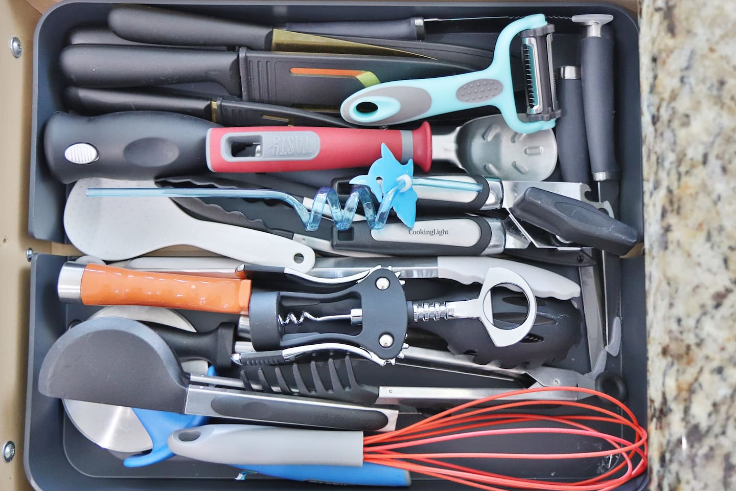 A large variety of kitchen tools including wine bottle opener, pizza cutter, and ice cream scooper