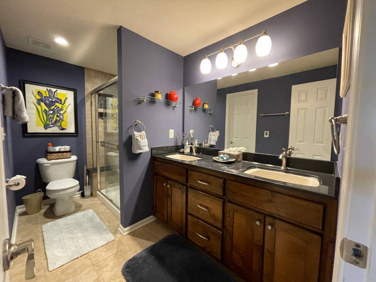 Large ceramic tiled bathroom with glass tile and natural stoned walk in shower and double sink. 