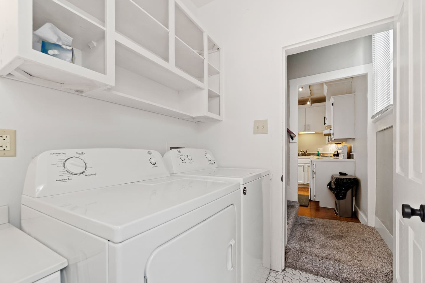 Bright and pristine all-white laundry area, equipped with a washer and dryer, offering a clean and functional space for all your laundry needs.