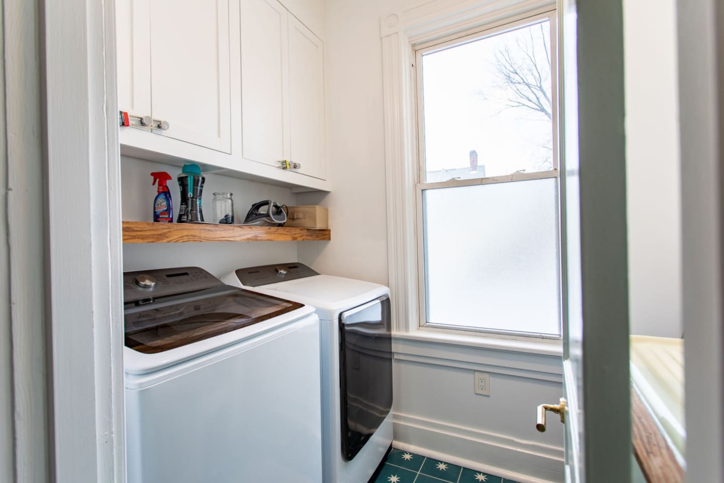 A practical laundry area featuring a washer and dryer, with a window that lets in natural light, creating a bright and efficient space for handling chores.