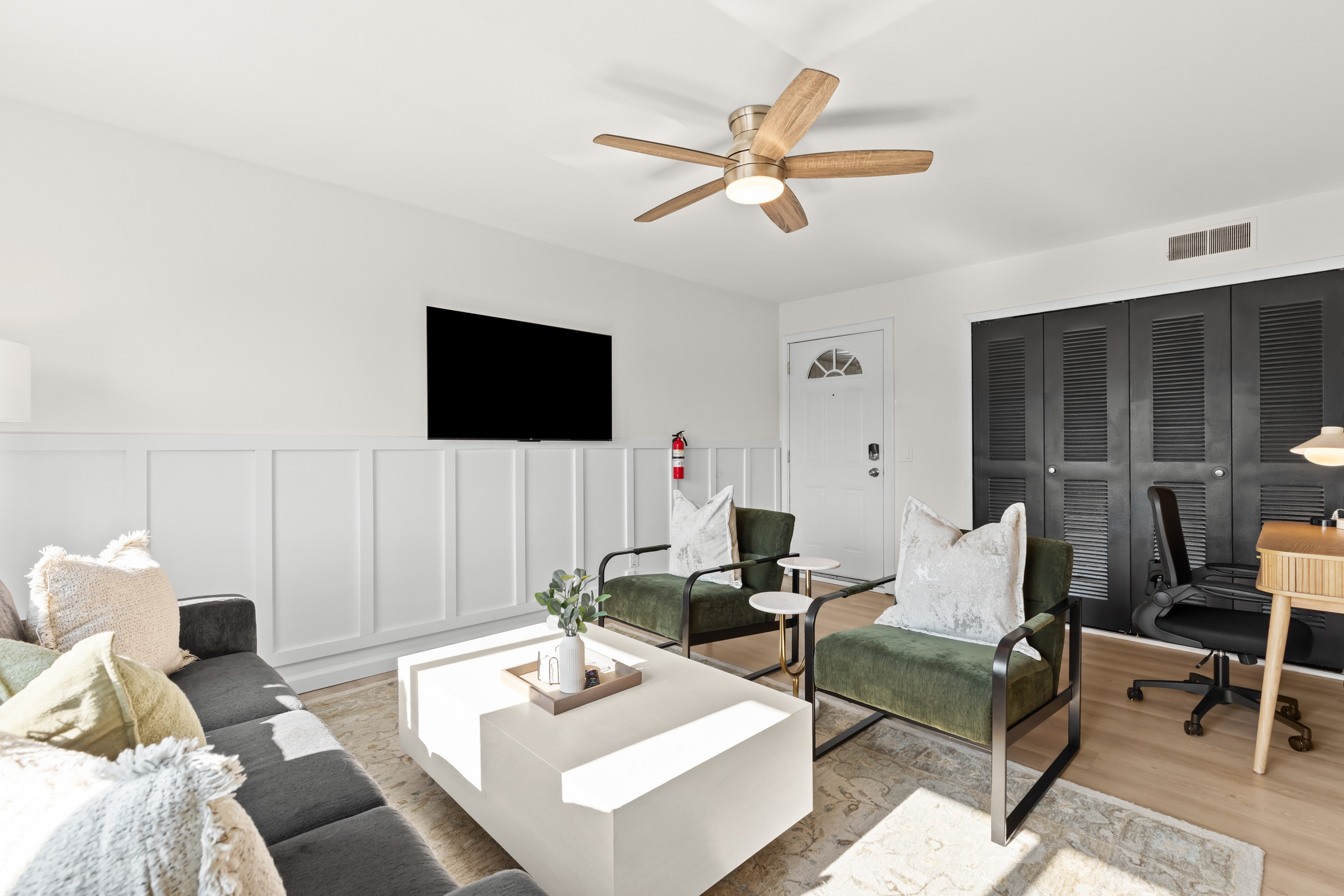Comfortable and stylish lounge area with Smart TV and paneled accent walls.