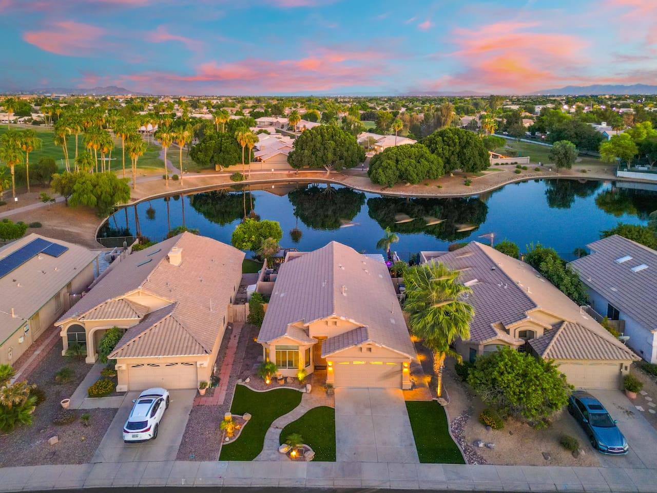 From the front curb to the lakeside backyard, the home delivers on every angle — lush turf, palm trees, a gleaming pool, and a front-row seat to Arizona's famous sunsets.