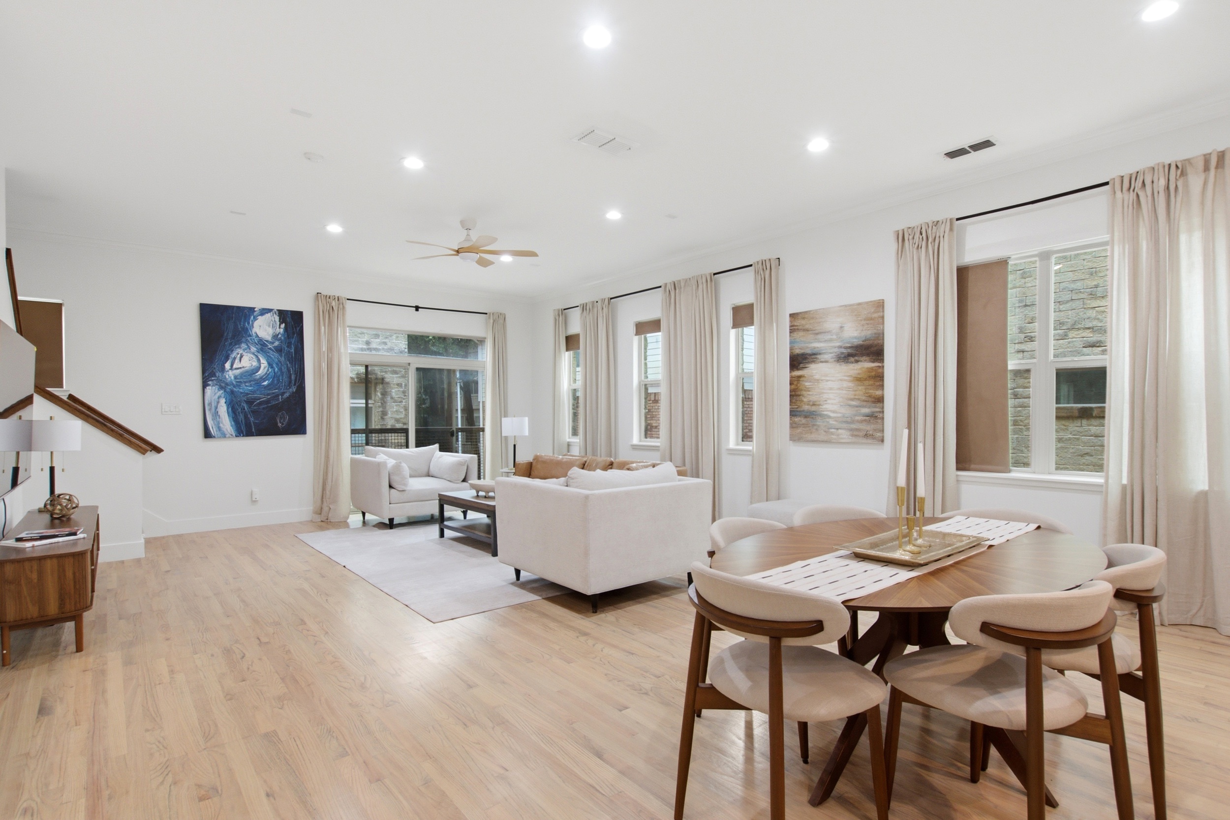 Open-plan dining area with seating for the full group, natural light from large windows, and a direct flow between the kitchen and living room. Easy for group meals at any hour.