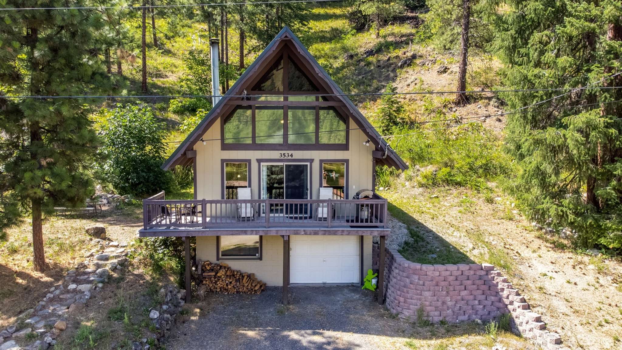 Classic A-frame architecture surrounded by forested hills.
