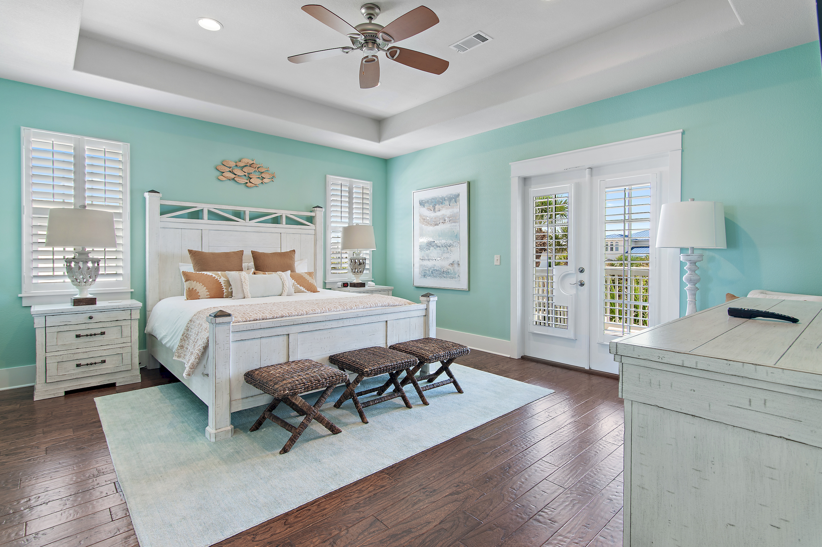 Relax in this spacious coastal bedroom, featuring a comfortable king bed, soft beach inspired décor, and plenty of natural light.