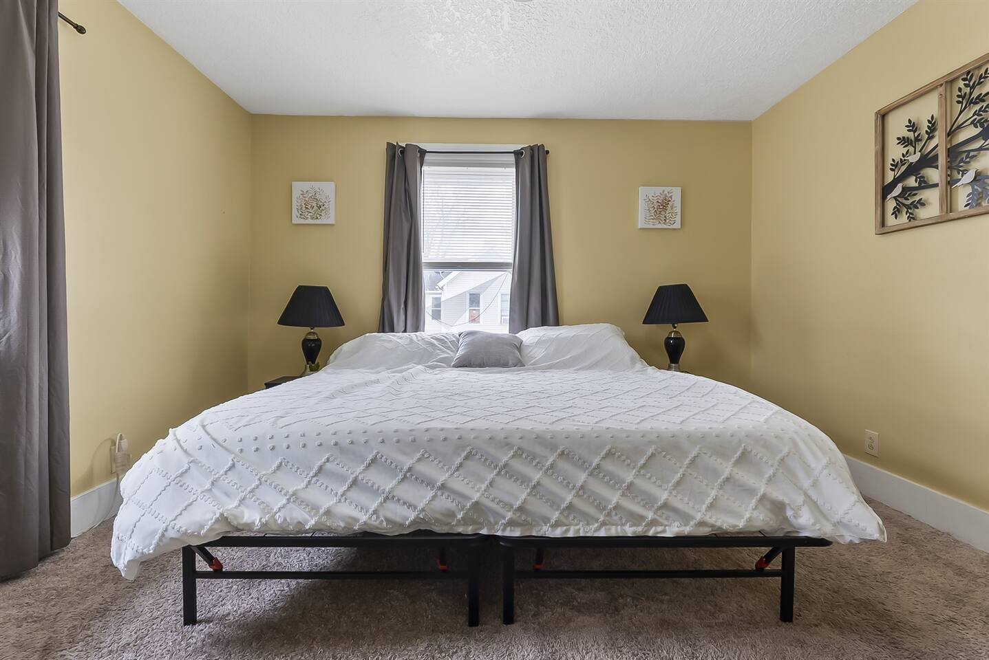 Spacious bedroom featuring a comfortable king-sized bed and large windows that fill the room with natural light.