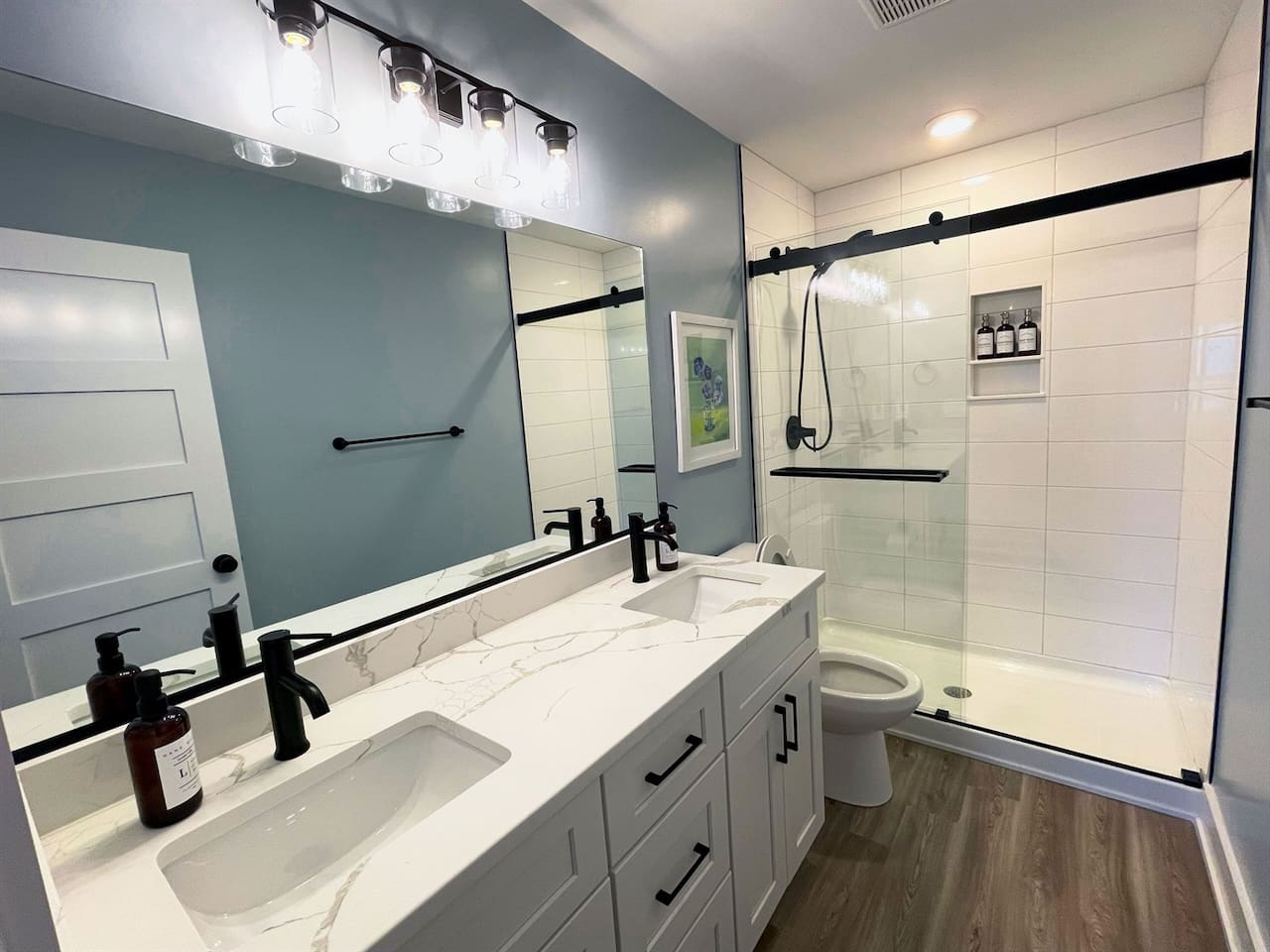 Primary bathroom with double vanity and a beautifully updated walk-in shower.